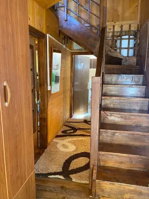 a wooden staircase in a room with a door at Tobis hostel in Ulcinj