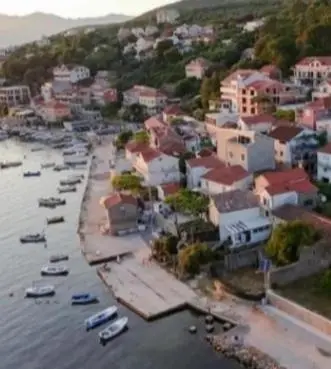 an aerial view of a town with boats in the water at Apartman u sumi nedaleko od mora in Bigovo