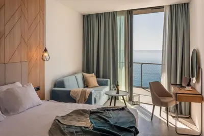 a hotel room with a bed and a view of the ocean at Hotel Ponta Plaza Conference & Spa in Budva