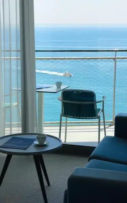 a room with a balcony with a table and a chair at Hotel Ponta Plaza Conference & Spa in Budva