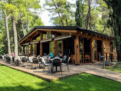 a pavilion with tables and chairs on a wooden deck at Gallery apartment in Podgorica