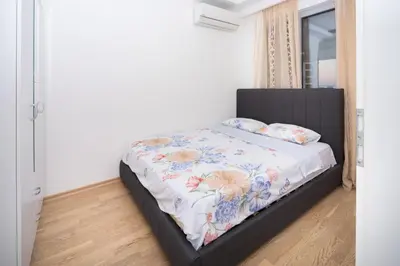 a bedroom with a bed with a black headboard at City center lux 2bdr apt with garage in Budva