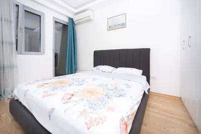 a bedroom with a large bed with a floral bedspread at City center lux 2bdr apt with garage in Budva