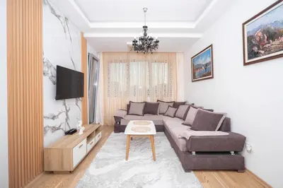 a living room with a couch and a tv at City center lux 2bdr apt with garage in Budva