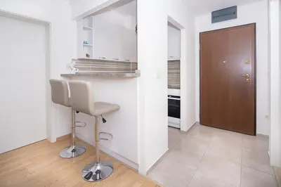 a kitchen with a counter and a stool in a room at City center lux 2bdr apt with garage in Budva