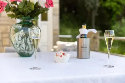 a table with two glasses of wine and a vase with flowers at Villa Sea La vie in Utjeha