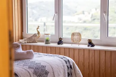 a bedroom with a window with figurines on a window sill at Villa Sea La vie in Utjeha
