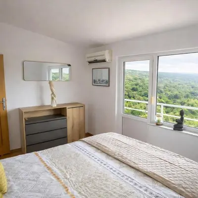 a white bedroom with a bed and a window at Villa Sea La vie in Utjeha