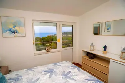 a bedroom with a bed and two windows at Villa Sea La vie in Utjeha