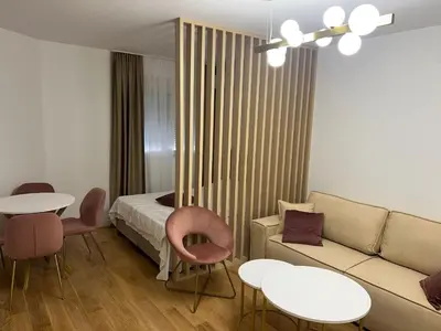 a living room with a bed and a couch and tables at Studio apartman Vivo Central in Podgorica