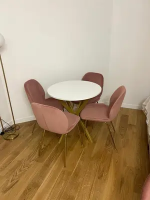 a white table and two pink chairs in a room at Studio apartman Vivo Central in Podgorica