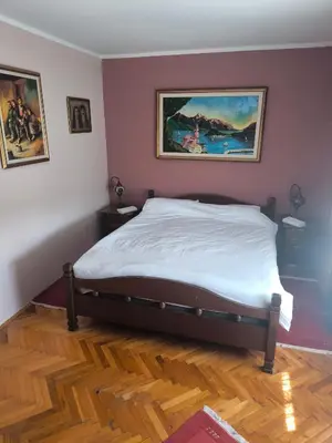 a bedroom with a bed with a painting on the wall at Vila Marija in Podgorica