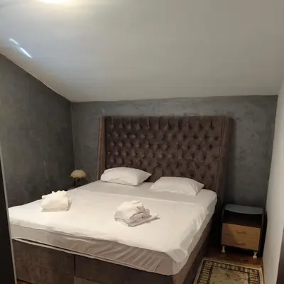 a bedroom with a large bed with two towels on it at Vila Marija in Podgorica
