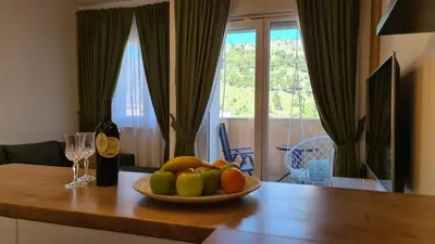 a bowl of fruit on a table with a bottle of wine at Marina City key Luxury Studio in Podgorica