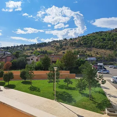 a park with trees and a hill in the background at Marina City key Luxury Studio in Podgorica