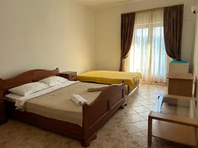 a bedroom with two beds and a glass table at Sunny Terraces in Cetinje