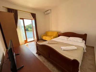 a bedroom with a bed and a tv and a chair at Sunny Terraces in Cetinje