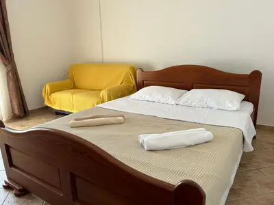 a bed with a chair and two towels on it at Sunny Terraces in Cetinje