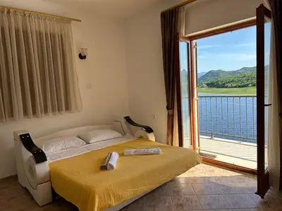 a bedroom with a bed and a large window at Sunny Terraces in Cetinje