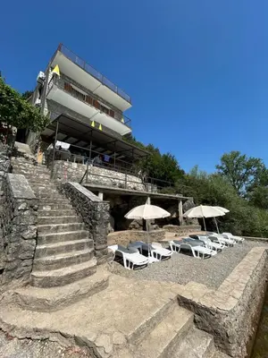 a beach with chairs and umbrellas and a building at Sunny Terraces in Cetinje