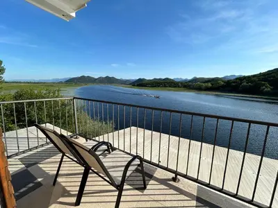 a bench on a balcony with a view of a river at Sunny Terraces in Cetinje