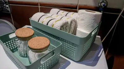 a basket of towels and toilet paper on a counter at Modern Apartment in City Center in Podgorica