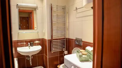 a bathroom with a sink and a toilet and a mirror at Modern Apartment in City Center in Podgorica