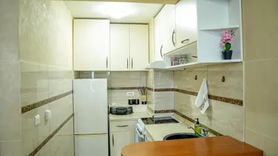 a kitchen with white cabinets and a white refrigerator at Modern Apartment in City Center in Podgorica