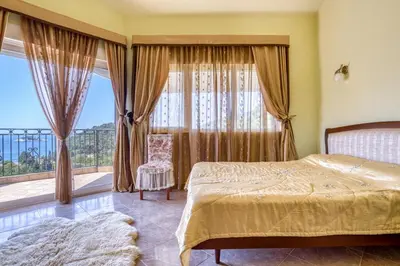 a bedroom with a bed and a large window at The view villa in Petrovac na Moru