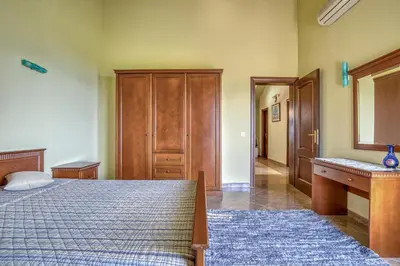 a bedroom with a bed and a wooden dresser at The view villa in Petrovac na Moru