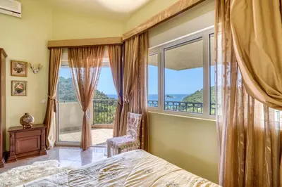 a bedroom with a bed and a large window at The view villa in Petrovac na Moru
