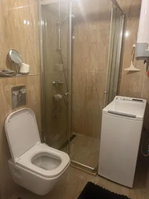a bathroom with a toilet and a glass shower at Nicks sea view apartment I in Bar