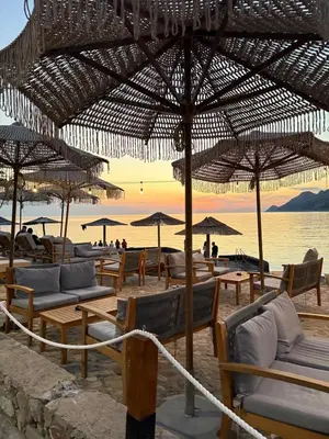 a group of chairs and umbrellas on a beach at Nicks sea view apartment I in Bar