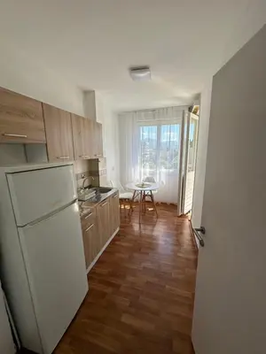 a kitchen with a white refrigerator and a table at Alex Apartments in Podgorica