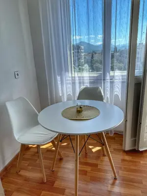 a white table and chairs in a room with a window at Alex Apartments in Podgorica