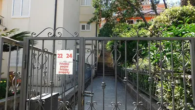 a gate with a sign on it in front of a house at Villa Jovana Sea View in Budva