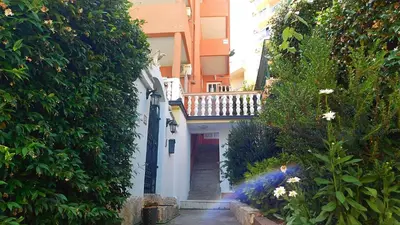 a small alley with a red door and some bushes at Villa Jovana Sea View in Budva