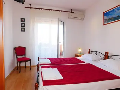 a bedroom with a large bed with a red blanket at Villa Jovana Sea View in Budva