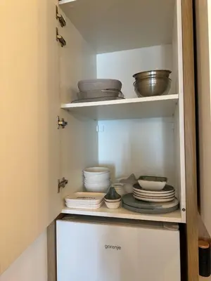a cupboard filled with plates and bowls in a kitchen at Apartman Diplomat in Budva
