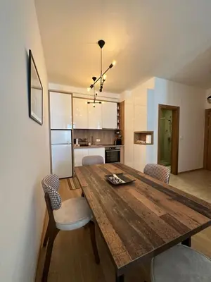 a kitchen and dining room with a wooden table and chairs at Apartman Diplomat in Budva