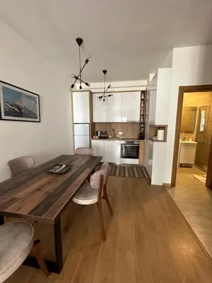 a kitchen and dining room with a wooden table and chairs at Apartman Diplomat in Budva