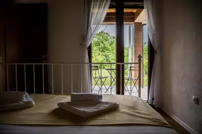 a bedroom with a bed and a balcony with a view at Paradise Valley in Rvaši