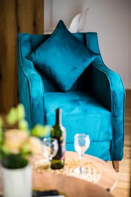a blue chair with a bottle of wine and glasses on a table at Paradise Valley in Rvaši