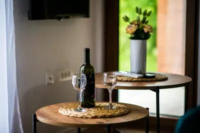 a bottle of wine and two glasses on two tables at Paradise Valley in Rvaši