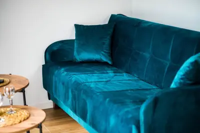 a blue couch in a living room with a table at Paradise Valley in Rvaši