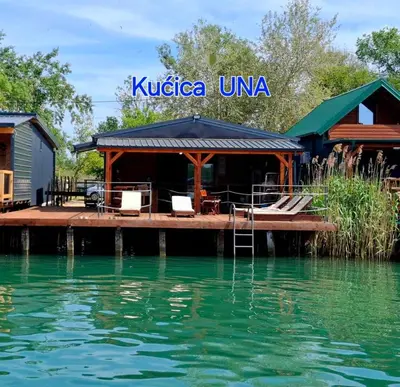 a house on a dock next to the water at Ada Bojana kucica Una in Ulcinj