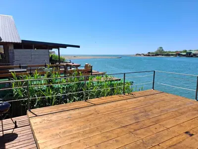 a wooden deck with a view of the water at Ada Bojana kucica Una in Ulcinj