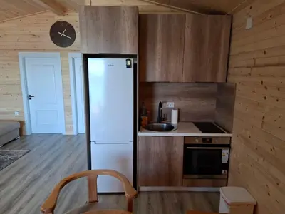 a kitchen with a refrigerator and a clock on the wall at Ada Bojana kucica Una in Ulcinj