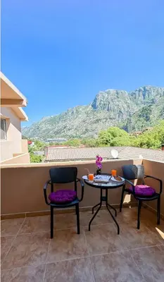 a patio with two chairs and a table on a balcony at Apartment Pavle near the center with a view in Kotor