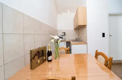 a kitchen with a wooden table with a bottle of wine at Apartment Pavle near the center with a view in Kotor